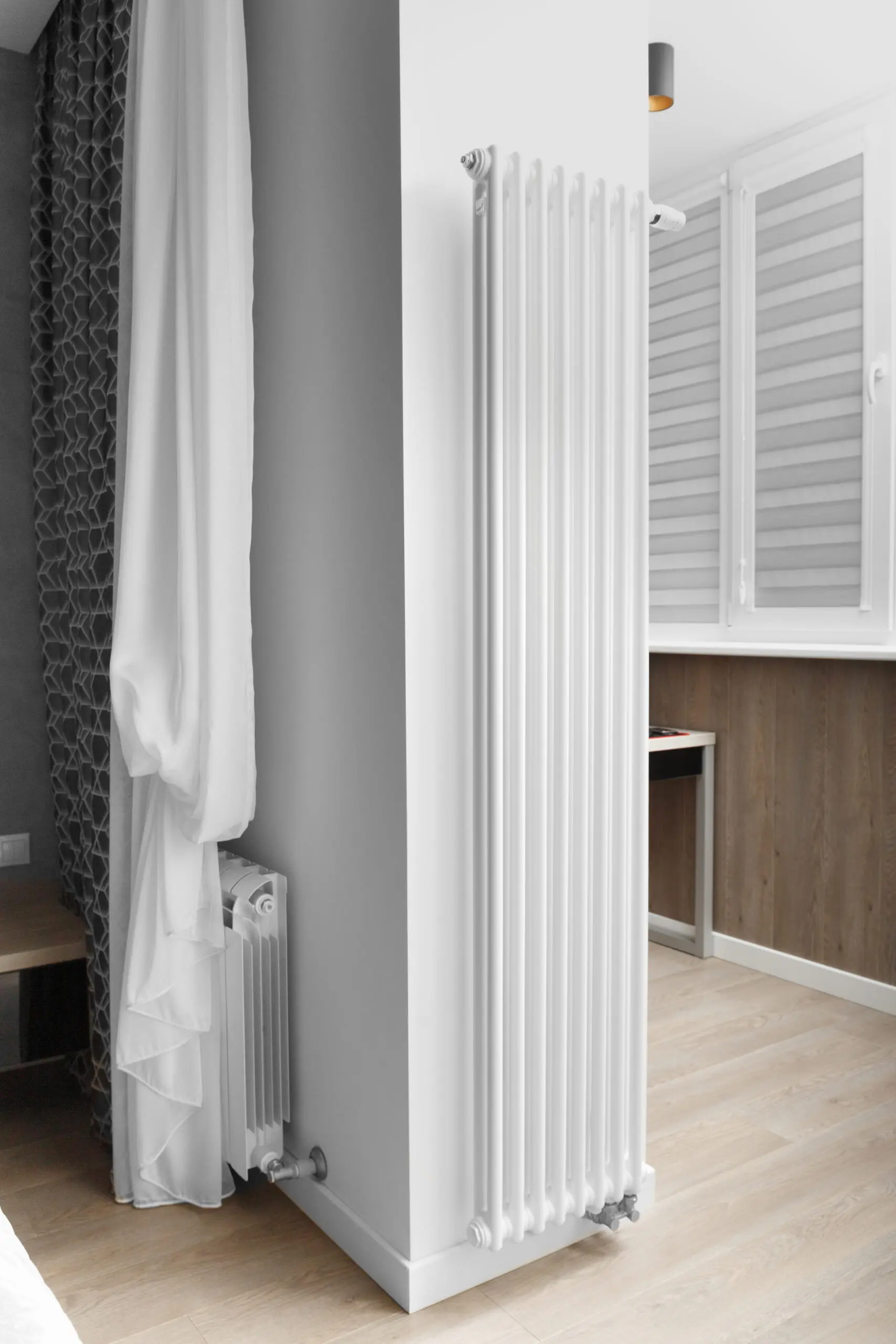Designer vertical heating radiator on the wall in the interior of an apartment, house.